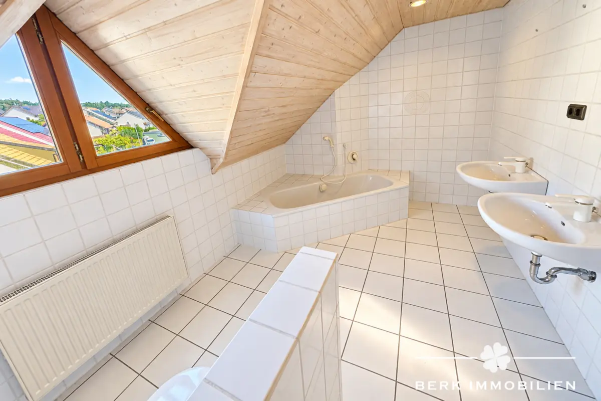 Helles Dachbad mit Badewanne und Doppeltwaschbecken