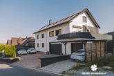 Straßenansicht - BERK Immobilien – einzigartige Luxusimmobilie: Naturverbunden und hochmodern in ruhiger Lage von Großostheim