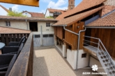 Blick vom Balkon auf den Innenhof KI-Generiert - BERK Immobilien – Vielseitiges Zweifamilienhaus mit viel Platz in Mömlingen